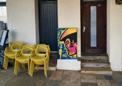 Personnage peint sur un petit coffret technique Telecom, sur les quais de la Nive, à coté d'un bistrot, entre deux portes extérieures