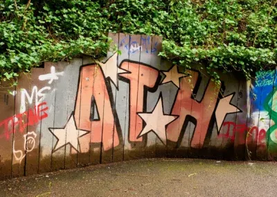 Des lettres peintes sur un mur de retenue de terre, le long d'un passage au bord de la Kelvin River