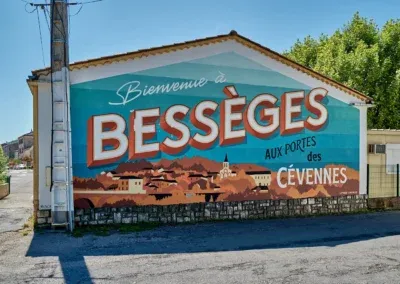 Street Art en Cévennes 1 Panneau d'accueil à l'entrée de ville de Bessèges (Gard) flamboyant et coloré avec un lettrage soigné (collectif Lettres Capitales)